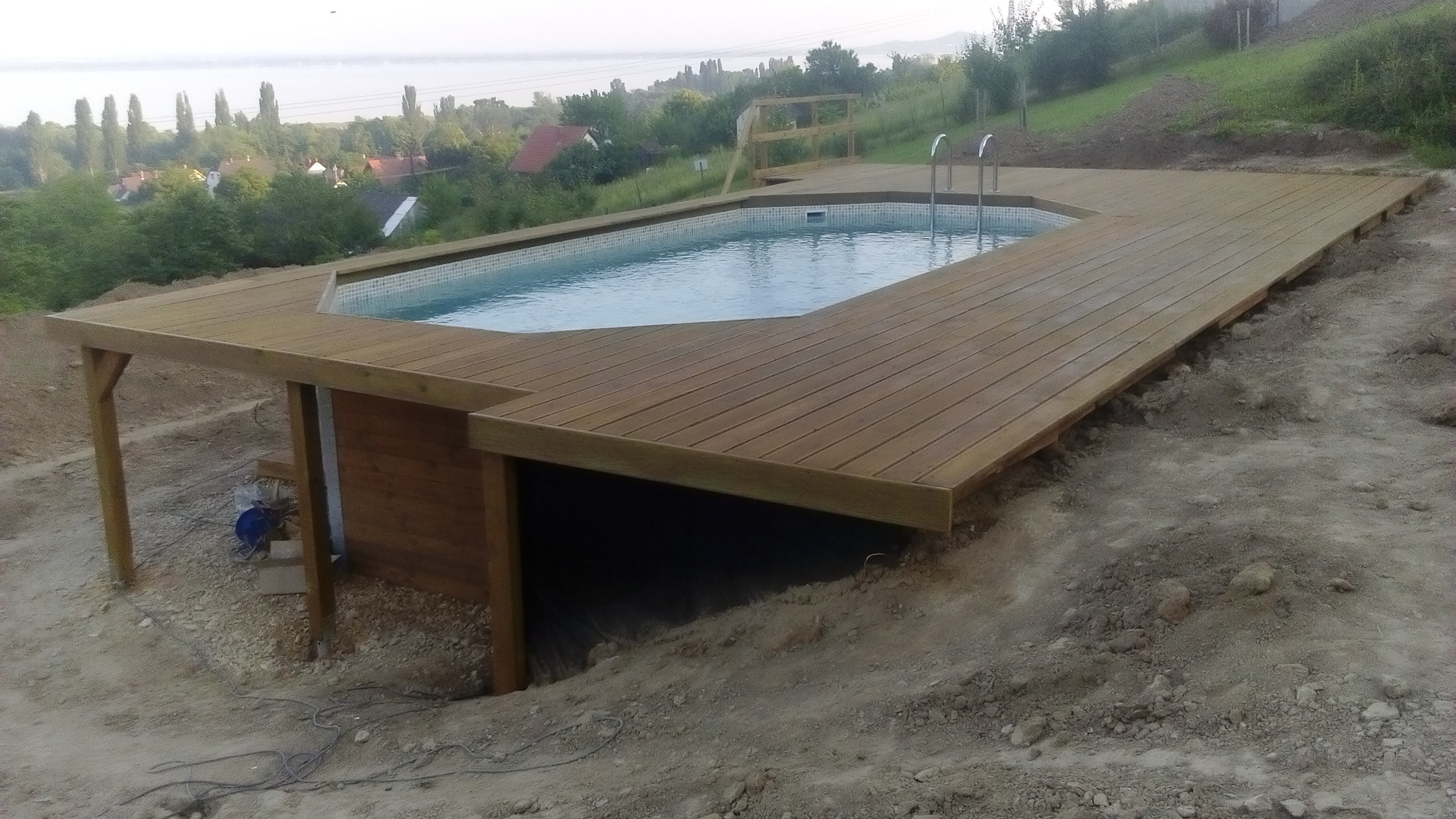 Medence építés domboldalba, napozóterasszal térbe illesztett medence.